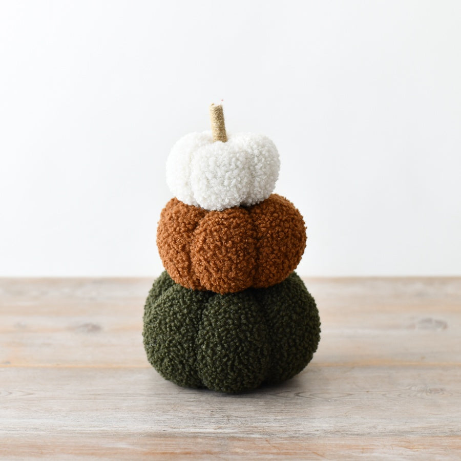Set of three stacked bouclé pumpkins in forest green, burnt orange and white with a natural twig stem