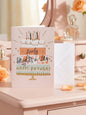 Lovely Daughter-in-Law Happy Birthday card — blush pink illustrated cake design, elegant dressing table lifestyle photo with perfume and roses