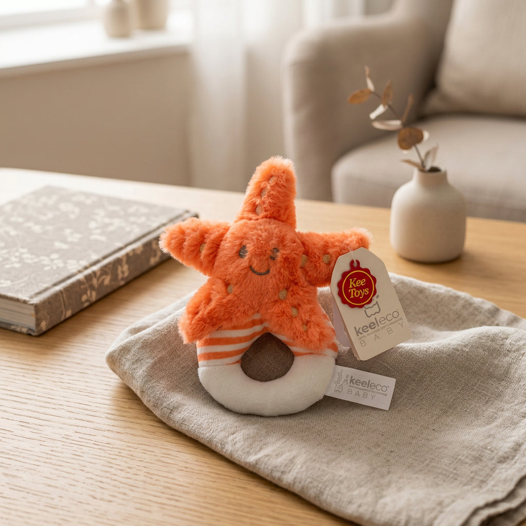 Keeleco orange starfish soft toy with embroidered face, spotted detailing and a cream and orange ring.