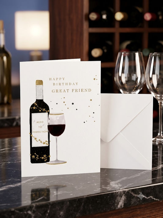 Happy Birthday Great Friend wine card lifestyle — card upright on dark marble with wine glasses and bottle rack background