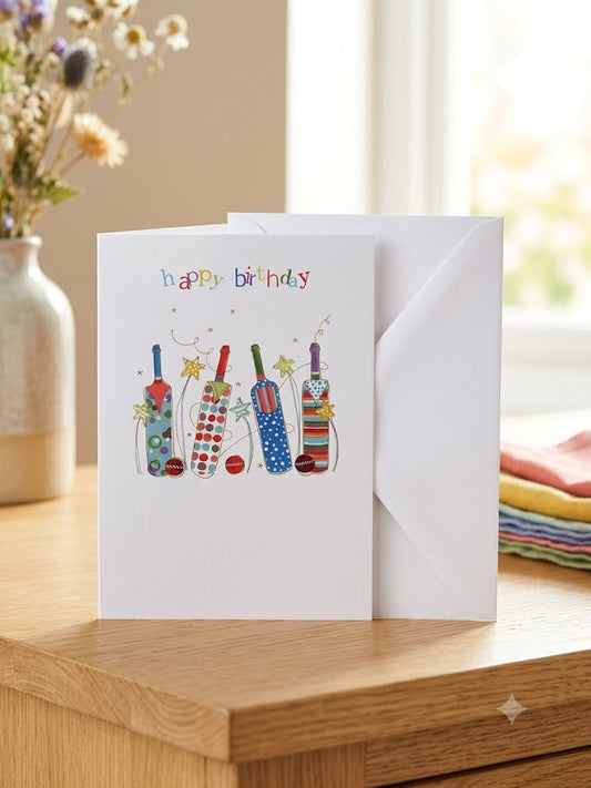 Happy Birthday cricket card — colourful illustrated cricket bats and stars, warm natural light lifestyle photo with flowers and colourful linens