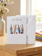 Happy Birthday cricket card — colourful illustrated cricket bats and stars, warm natural light lifestyle photo with flowers and colourful linens
