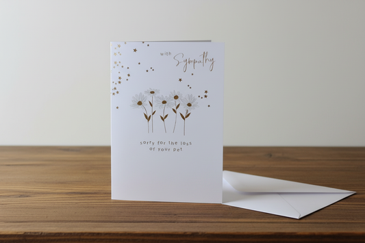 Pet sympathy daisy card standing upright spine-left slightly open in a cosy lifestyle setting