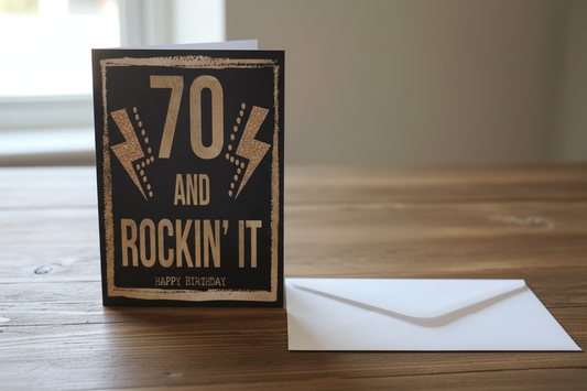 70 and Rockin' It birthday card standing upright spine-left slightly open in a cosy lifestyle setting