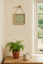 Live Simply Bloom Wildly small hanging sign in a cottage-style setting