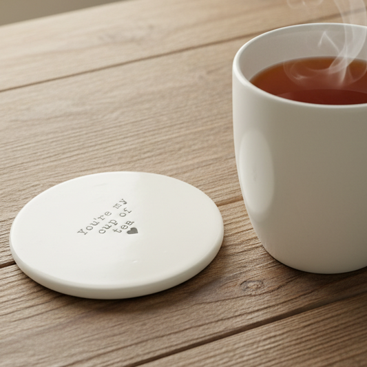 You're my cup of tea ceramic coaster styled on a rustic wooden surface beside a white mug of tea