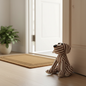 Striped fabric dog doorstop styled in a bright hallway