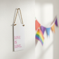 Love Is Love mini sign hung on a white wall with rainbow bunting