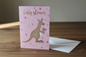 Baby shower kangaroo card standing upright spine-left slightly open in a cosy lifestyle setting