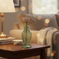 Green glass fish-shaped vase in a cosy home setting