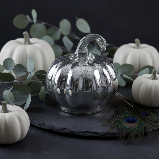 Mercury glass silver pumpkin ornament styled with white pumpkins and dried botanicals in an elegant autumn display