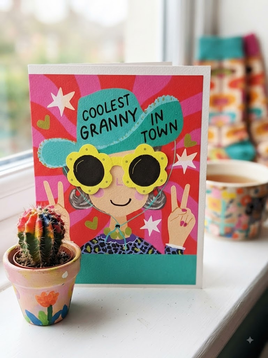 Coolest Granny In Town card with illustrated granny in teal cowboy hat and yellow flower sunglasses on vibrant sunburst background