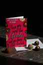 Happy Birthday Husband chocolate card upright with white envelope on dark marble with chocolate truffles