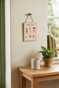 Fruit & Veg hanging sign displayed above a wooden table beside a mug and potted fern